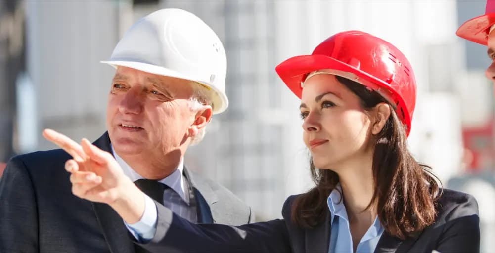 Two professionals discussing facility management, one pointing to demonstrate a concept